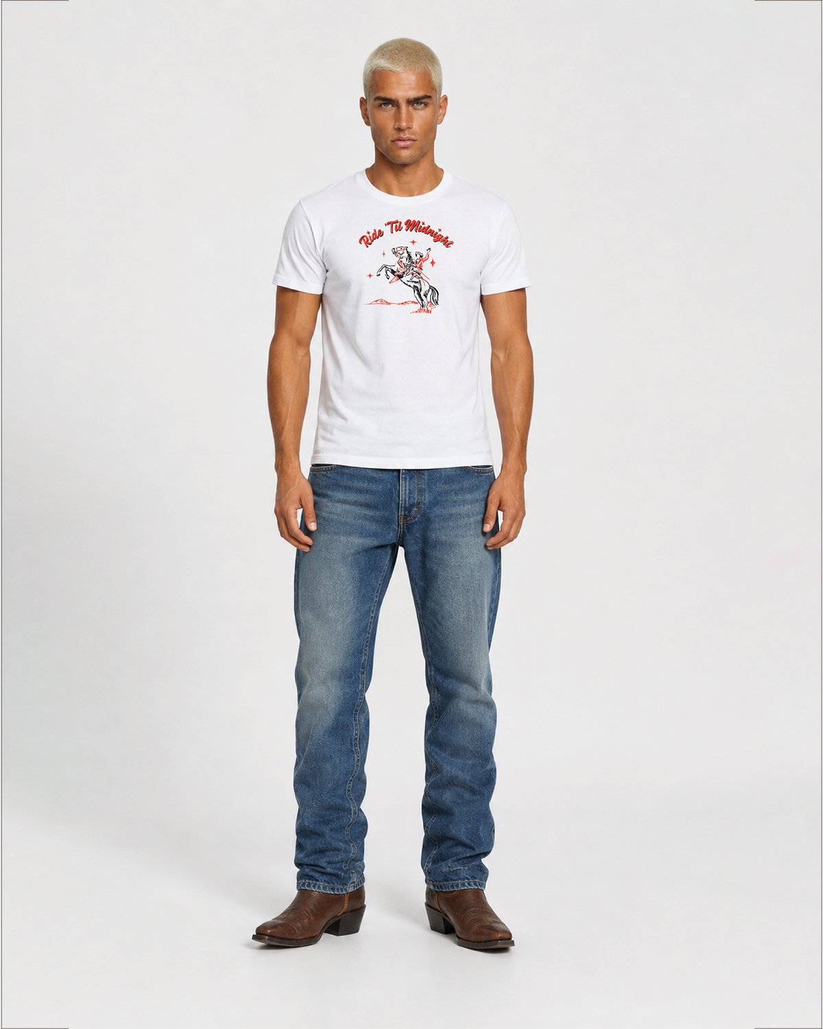 Male model wearing the white "Ride 'Til Midnight" western cowboy graphic t-shirt with jeans and boots, full-body standing shot